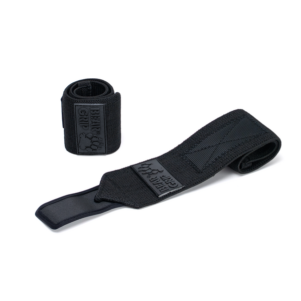 BEAR GRIP black wrist wraps, one upright and one laid flat, with textured straps and logo patch on a white background.